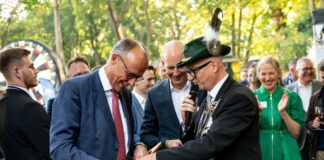 Bundeskanzler Friedrich Merz (CDU) bekommt beim Schützenfest der Sauerländer Botschaft Badeschlappen mit der Aufschrift «Rambo Zambo» geschenkt.