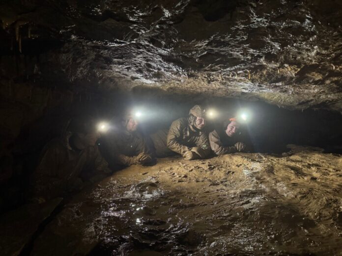 Die Höhlenforscher arbeiten sich durch den Schlamm in der Kluterthöhle voran.