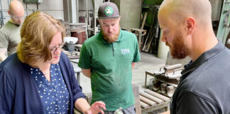 Kerstin Griese, Julien und Philipp Vitz schauen sich ein ein Aluminiumgussteil an. Foto: Büro Griese