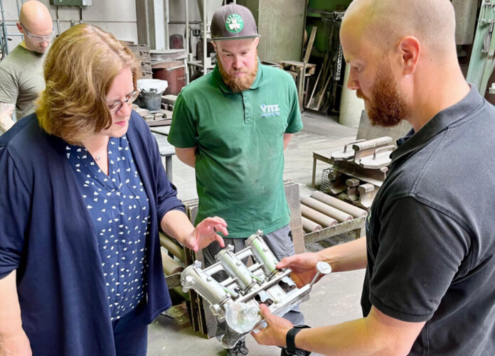 Kerstin Griese, Julien und Philipp Vitz schauen sich ein ein Aluminiumgussteil an. Foto: Büro Griese