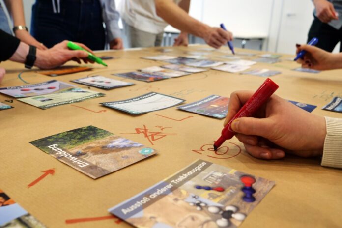 Beim VHS-Workshop wird der Klimawandel von den Teilnehmenden mit 42 Spielkarten „erpuzzelt“. Foto: Carsten Neise