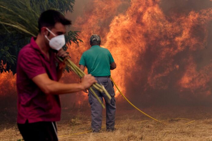 Einwohner kämpfen gegen ein Feuer, das sich auf das Dorf Rebordondo in der Nähe von Ourense im Nordwesten Spaniens ausbreitet. 