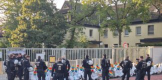 Mit einer Sitzblockade protestieren Aktivisten vor einem Bundeswehr-Gebäude.