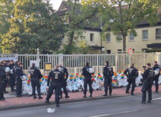 Mit einer Sitzblockade protestieren Aktivisten vor einem Bundeswehr-Gebäude.