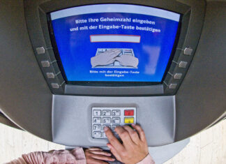 Ein Unbekannter hebt Geld an einem Automaten ab. Foto: Polizei/Symbolfoto