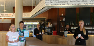 Die städtische Gleichstellungsbeauftragte Annegret Pollmann (2.v.l.) präsentiert zusammen mit Fachberaterin Claudia Sciannimanica vom SKFM Mettmann (1.v.l.) und dem Team der Kulturbar in der Stadthalle Erkrath das bundesweite Hilfsangebot für Frauen. Foto: Stadt Erkrath