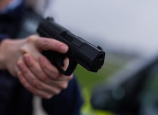 Ein Polizist hält eine Pistole vom Typ Walther P99 in den Händen (Archivfoto)