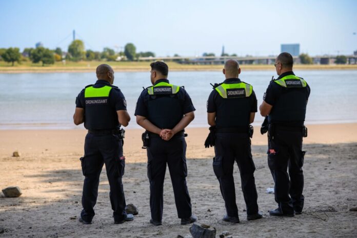 Mitarbeiter des Düsseldorfer Ordnungsamtes kontrollieren das Badeverbot im Rhein. 
