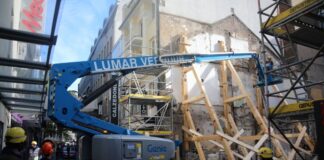 Einsatzkräfte stützen eine einsturzgefährdete Gebäudewand an einer Baustelle.