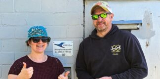 Ausbildungsleiterin Elisabeth Liersch vom Aeroclub Ratingen e.V. (links) und Ausbildungsleiter Dominik Sutara vom Sportflug Niederberg e.V. (rechts) vor der Plakette der offiziellen Ausbildungsstätte des Aeroclub. Foto: NRW e.V.