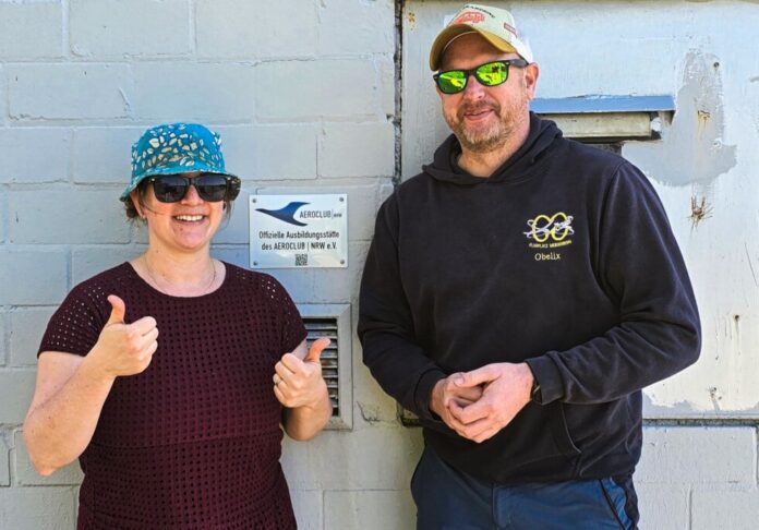 Ausbildungsleiterin Elisabeth Liersch vom Aeroclub Ratingen e.V. (links) und Ausbildungsleiter Dominik Sutara vom Sportflug Niederberg e.V. (rechts) vor der Plakette der offiziellen Ausbildungsstätte des Aeroclub. Foto: NRW e.V. Ausbildungsleiterin Elisabeth Liersch vom Aeroclub Ratingen e.V. (links) und Ausbildungsleiter Dominik Sutara vom Sportflug Niederberg e.V. (rechts) vor der Plakette der offiziellen Ausbildungsstätte des Aeroclub. Foto: NRW e.V.