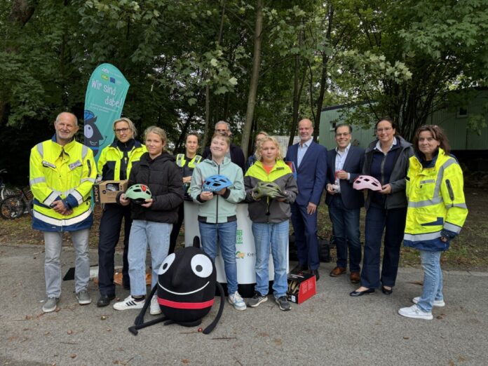 Ein Helm kann bei einem Unfall ein Lebensretter sein. Dafür engagieren sich: Bojan Smigoc (Kreisverkehrswacht), Jessica Werner und Anja Stropp (Polizei), Schulleiter Christoph Jakubowski, Claudia Feller, Stephan Kopp und Sascha Becker (Kreis Mettmann), Britta Sieper (Puky), Tanja Smigoc (Kreisverkehrswacht) und drei Schüler der Liebfrauenschule. Foto: Kreis ME
