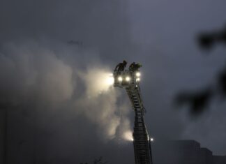 Über eine Drehleiter kämpfen Feuerwehrleute an der Sperrmüll-Halle gegen den Brand.