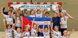 Weltmeisterschaft: Wülfrather Mini-Handballerinnen vertreten Kuba Die Handballmannschaft des TB Wülfraths mit Alexander Melcher, einem der Trainer der Mannschaft, und Niko Papanikolau, dem kaufmännischen Leiter der Neander Energie. Foto: Neander Energie