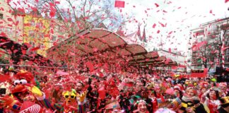 Perücken auf dem Kopf, Konfetti in der Luft: Karnevalisten beim Feiern. (Archivbild)