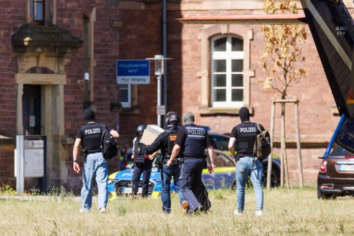 Kurz nach dem Angriff in Bielefeld wurde der mutmaßliche Täter in Karlsruhe einem Haftrichter vorgeführt. Hier tragen Polizisten Akten vom Helikopter zu einem Fahrzeug. (Archivbild)