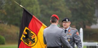Brigadegeneral Marco Eggert (r) übergibt eine Deutsche Fahne beim Feierlichen Appell für das neu aufgestellte Artilleriebataillon 215 in der General-Feldmarschall-Rommel-Kaserne.