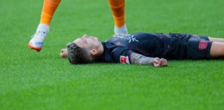 Bayer Leverkusens Kapitän Alejandro Grimaldo liegt nach einem Zusammenprall mit dem eigenen Mann benommen auf dem Boden. 