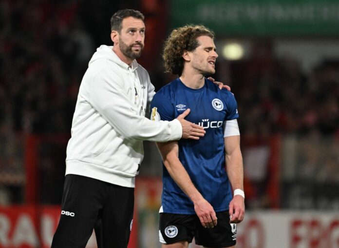 Bielefelds-Trainer Kniat tröstet seinen Spieler Corboz (r.)