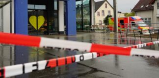 Die Polizei hat vor dem Supermarkt Absperrband angebracht, an der Seite steht ein Rettungswagen.