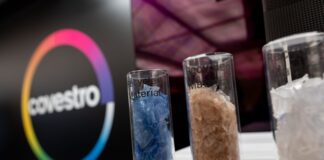 Arabischer Staatskonzern übernimmt Chemiefirma Covestro Eine deutsche Firma wird arabisch: Das Logo des Spezialchemie-Konzerns in einem Firmen-Showroom, davor Gläser mit Covestro-Materialien.