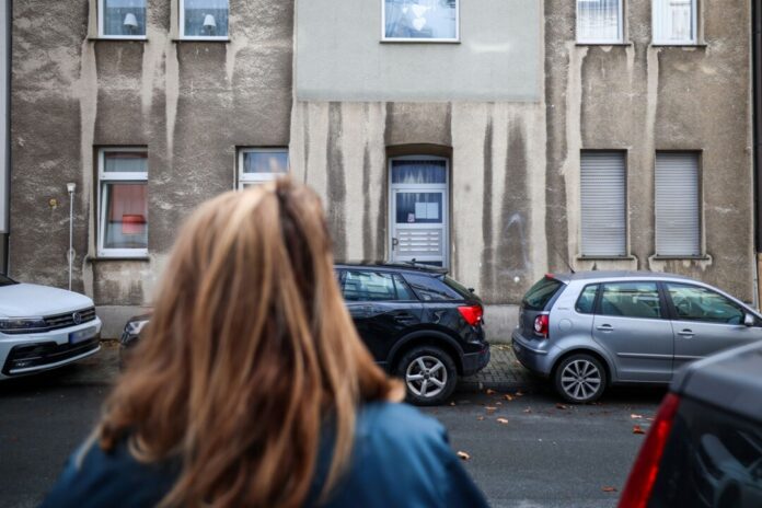 Zwölfjährige bei Polizeieinsatz lebensgefährlich verletzt Eine Frau steht vor dem Mehrfamilienhaus, in dem ein zwölfjähriges Mädchen bei einem Polizeieinsatz durch Schüsse lebensgefährlich verletzt worden.