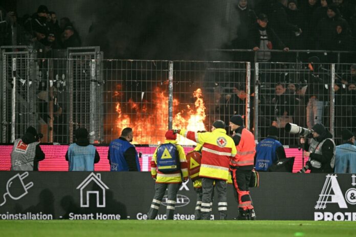 1. FC Köln - Eintracht Frankfurt Im Frankfurter Fanblock brennt ein Feuer.