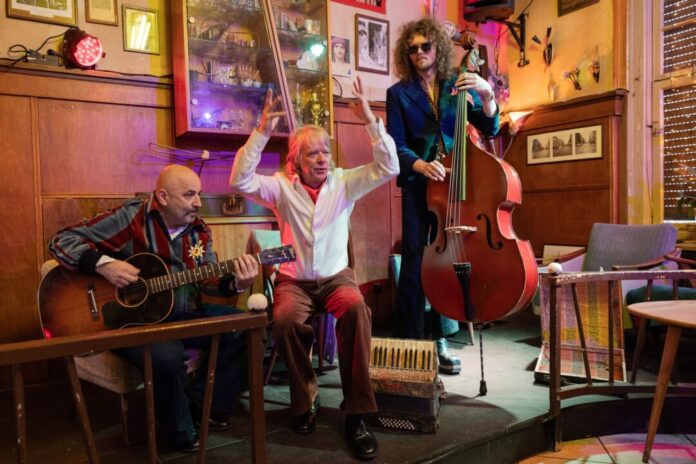 Helge Schneider zu neuer Tournee "Ellbogen vom Tich" Nur mit Gitarrist und Bassist steht Schneider ab 2026 wieder auf der Bühne. Er selbst wechselt zwischen verschiedenen Instrumenten.