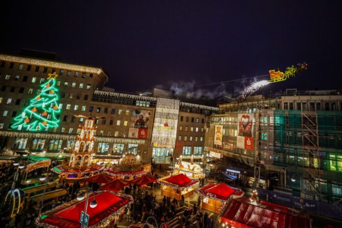 In einem Schlitten, der an einem Stahlseil befestigt ist, fliegt der Weihnachtsmann zwei Mal täglich über den Weihnachtsmarkt in Bochum.