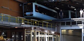 Die Schwebebahn gestern und heute. Ein Wagen der ersten Baureihe 1900 steht auf einem Tieflader unter einem Wagen der aktuellen Baureihe in der Werkstatt der Schwebebahn. (Archivbild)