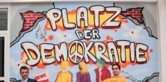 Ratingen hat jetzt einen „Platz der Demokratie“ Bitte Platz nehmen: Ahmet Özdemir (links), Leiter des Medienzentrums, und Graffiti-Künstler Mel Ritschel haben die Sitzecke vor der neu gestalteten Wand im 2. Obergeschoss schon mal getestet. Foto: Stadt Ratingen
