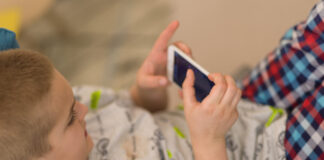 Gaming: Was Kinder in die Kostenfalle lockt Ein Kind spielt an einem Smartphone. Foto: VZ NRW/adpic