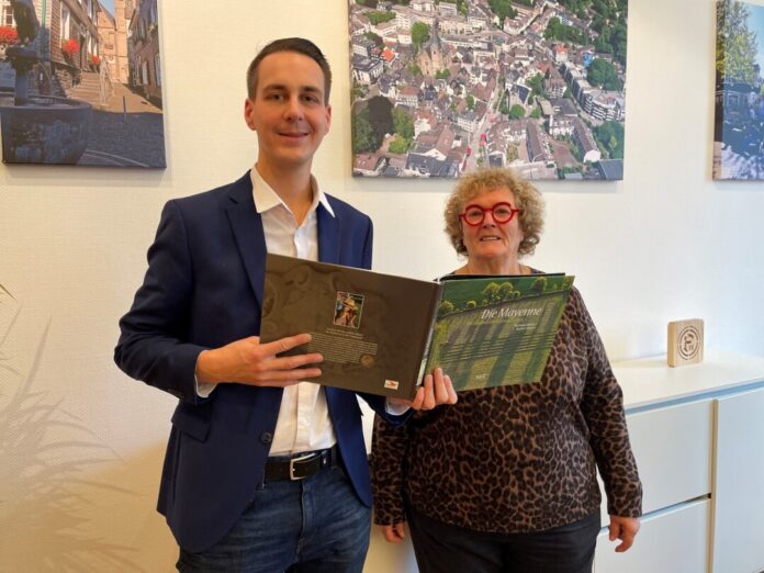 Mireille Coupard hat Bürgermeister André Bär einen Bildband über den Fluss Mayenne geschenkt, der durch Laval fließt und dem Departement, zu dem auch Mettmanns Partnerstadt gehört, seinen Namen gegeben hat. Foto: Kreisstadt Mettmann