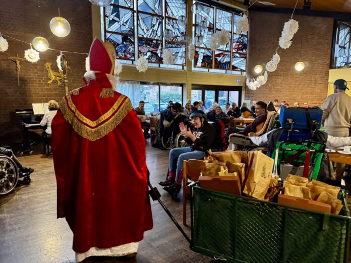 Nikolausfeier_Lebenshilfe_1 Der Nikolaus verteilt Geschenktüten an die Gäste der Feier im Pfarrsaal von St. Peter und Paul. Foto: Lebenshilfe Kreis Mettmann