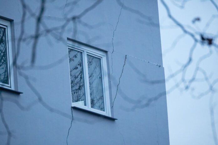 Haus droht einzustürzen Risse sind an der Fassade eines Mehrfamilienhauses zu sehen. Weil an mehreren Stellen der Boden abgesackt ist, ist das zweistöckige Haus einsturzgefährdet. (Archivbild)