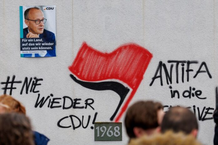 Rechtswidrige Durchsuchung nach Graffitis in Menden An die Schützenhalle in Menden hatten Unbekannte in der Nacht vor einem Wahlkampfauftritt des damaligen Kanzlerkandidaten Friedrich Merz (CDU) Schriftzüge an eine Wand gesprüht. (Archivfoto)