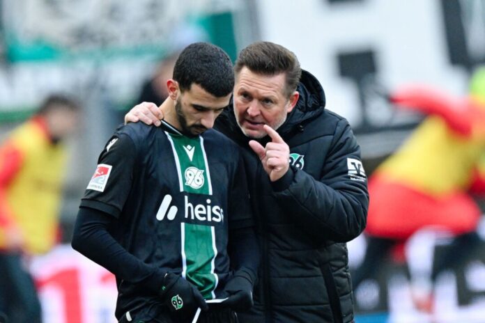 1. FC Kaiserslautern - Hannover 96 Trainer Christian Titz (r, Hannover 96) spricht bei der Einwechslung mit Waniss Taïbi (Hannover 96).