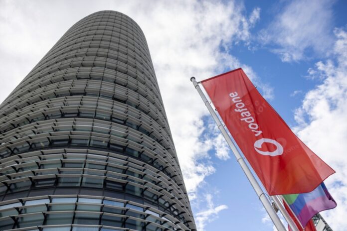 Vodafone-Flaggen vor der Deutschlandzentrale Der Grund, dass Vodafone wieder etwas mehr Geld in die Kassen bekommt, ist die Zusammenarbeit mit dem Wettbewerber 1&1. (Archivbild)