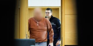 Handgranaten-Drohung in Bielefeld – Angeklagter schweigt Der Angeklagte kommt in Begleitung eines Justizbeamten in den Prozesssaal am Landgericht Bielefeld.