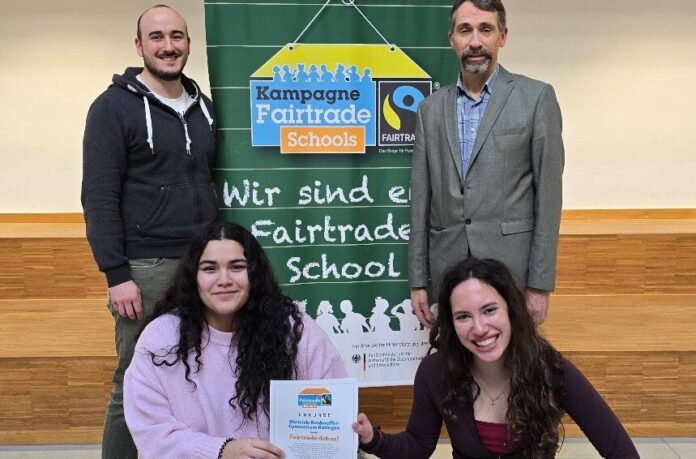 2026-03-02-Fairtrade-AuszeichnungDBG Uwe Florin, Schulleiter des Dietrich-Bonhoeffer-Gymnasiums (hinten rechts), freut sich mit André Edenharter, Koordinator der Schulkampagne, und den beiden Schülersprecherinnen Kayra (links) und Aline über die erneute Auszeichnung als „Fairtrade-School“. Foto: Dietrich-Bonhoeffer-Gymnasium