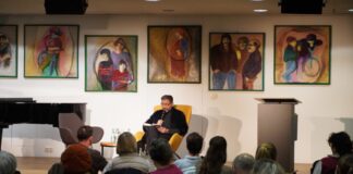 Autor Gianni Jovanovic begeistert im Ratinger Medienzentrum Im voll besetzten Lesecafé des Medienzentrums und umrahmt von Bildern des Ratinger Künstlers Yildirim Denizli las der Autor Gianni Jovanovic aus seinem Werk und appellierte eindringlich für einen fürsorglichen Umgang miteinander. Foto: Stadt Ratingen