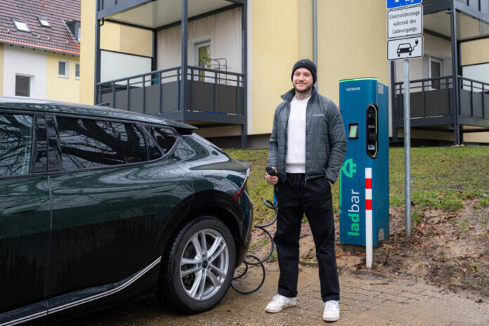 Vonovia intsalliert Quartiersladestation in Heiligenhaus_2 Vonovia-Mitarbeiter Ruven Vaaßen zeigt, wie das Laden an der neuen Wallbox an der Danziger Straße in Heiligenhaus funktioniert. Foto: Vonovia / Bierwald