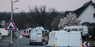 Atommüll-Transport in NRW: Polizei startet Großeinsatz Polizeifahrzeuge stehen an der Zufahrt zum Forschungszentrum Jülich.