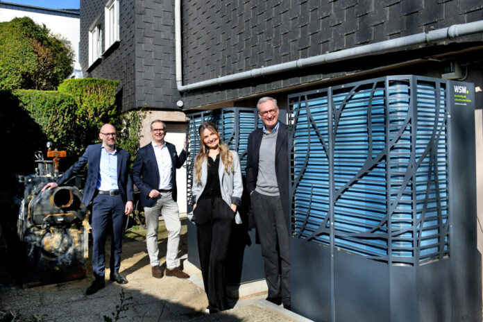 WSW Wuppertaler Stadtwerke GmbH | Bromberger Straße 39 | 4228 Alte und neue Wärmeversorgung im gwg-Quartier Nibelungenstraße: links der alte Öl-/Gas-Heizkessel, rechts die beiden Außeneinheiten der neuen Wärmepumpe. Von links: gwg-Geschäftsführer Oliver Zier, Andy Völschow (Leiter Kunden- & Quartierslösungen bei den WSW), Monika Nestorowicz (Referentin für das Quartiersmanagement bei der gwg), WSW-Vorstandsvorsitzender Markus Hilkenbach, Foto: Bettina Osswald/WSW