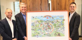 Ratingen: Wimmelbild zum 750-Jahre-Jubiläum Bürgermeister Patrick Anders (rechts) freut sich sehr über das gelungene Wimmelbild zum Stadtjubiläum, das Jesper Erichsen, Mitglied der Geschäftsführung, und Philipp Anger von DKV Mobility im Rathaus überreichten. Foto: Stadt Ratingen