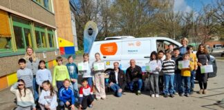 Kinder der 2., 3. und 4. Klasse, Laura Tillmanns und Silke Evers der GGS Herrenhauser Straße mit vollen Spendenkisten, der ehrenamtliche Tafel-Mitarbeiter Norman Schwannauer sowie Leiter der Tafel Mettmann der Diakonie im Kirchenkreis Düsseldorf-Mettmann Simon Wilde bei der Spendenübergabe. Foto: Ursi Jensen