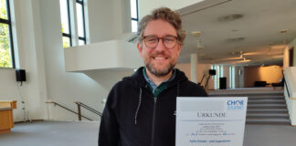 Chorleiter Patrick Jaskolka mit der Siegerurkunde des Wettbewerbs. Foto: TUP