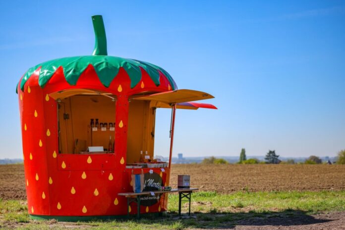 Früher Saisonstart für Erdbeeren Ein mobiler Verkaufsstand in der Form einer Erdbeere steht am Rande eines Parkplatzes in Dortmund.