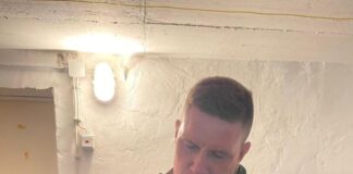 Mehrere Rettungsversuche: Feuerwehr holt Katze aus Mauerwerk Nach der Rettung hält ein Feuerwehrmann die Katze im Arm. (Foto Handout)