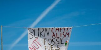 Aktivisten gegen Gaskraftwerke: Großes Klimacamp startet Ein Banner mit der Aufschrift «Burn Capitalism not Fossil Fuels» ist an einem Seil im Klimacamp befestigt. (Archivbild)